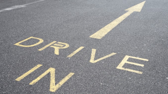 Asphalt-straße mit dem schriftzug "drive-in" und einem pfeil