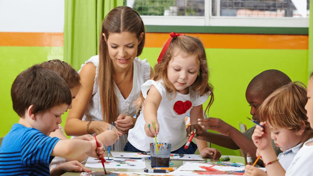 Kinder & Erzieherin malen im veganen Kindergarten